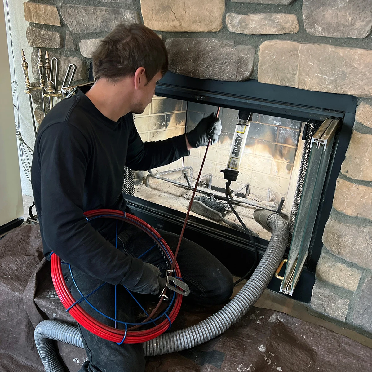 Technician using specialized equipment to inspect a fireplace chimney